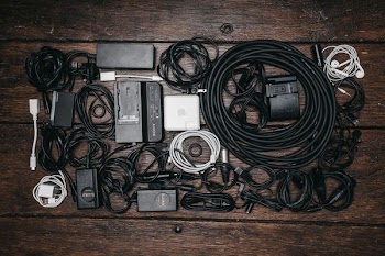 black cable lot and electronic devices on brown wooden surface