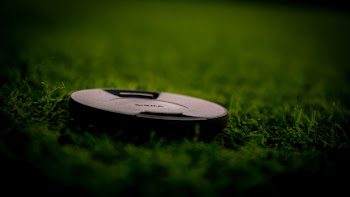 Black Camera Lens Cover on Green Grass