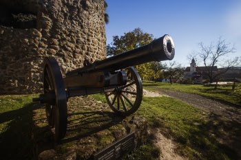 Black Cannon in Front of the Brick Wall Building