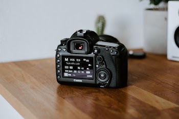 black Canon DSLR camera on table