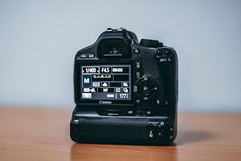 Black Canon Dslr Camera on Wooden Table