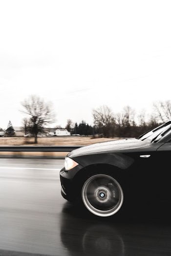 black car running in road