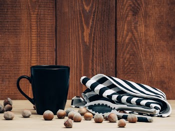Black Ceramic Mug Surrounded by Chestnuts