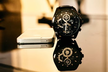 Black Chronograph Watch Besides Iphone on Table