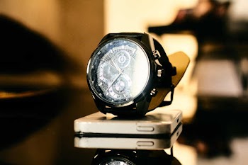 Black Chronograph Watch on Smartphone on Table