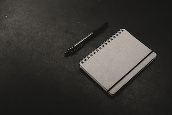 black click pen beside notebook