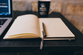 Black Click Pen on White Notebook on Black Wooden Surface