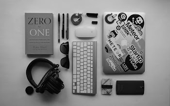 black corded headphones, silver MacBook, Apple wireless keyboard, and Apple Magic Mouse