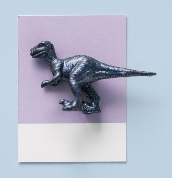 Black Dinosaur Toy on Purple and White Paper