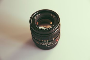 black DSLR camera lens on white surface