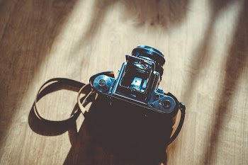 Black Dslr Camera on Brown Surface