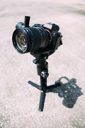 black DSLR camera on tripod stand