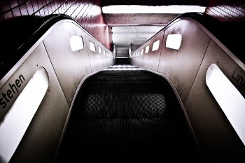 Black Escalator Near Red Wall Tiles