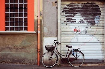 black female bicycle leaning on gray wall