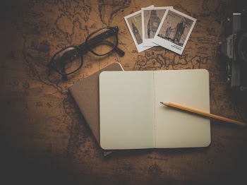 Black Framed Eyeglasses Beside Big Ben Pictures and Notebook
