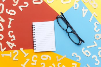 Black Framed Eyeglasses Beside Notebook