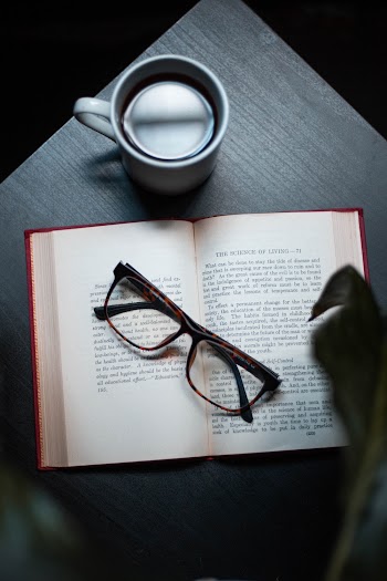 Black Framed Eyeglasses On Book