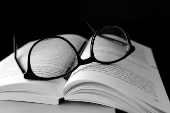 Black Framed Wayfarer Eyeglasses on Book