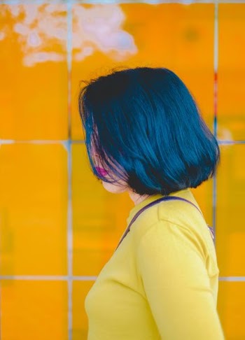 black haired woman in yellow long-sleeved top