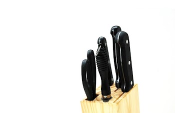 Black Handled Kitchen Knife on Beige Wooden Pallet