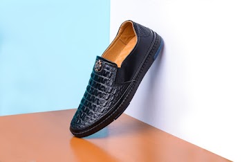 Black Leather Shoe Leaning on Wall