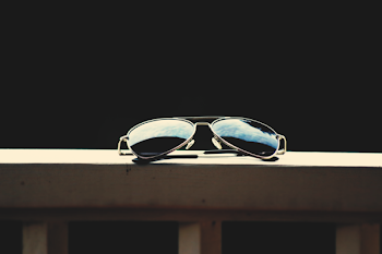 Black Lens Aviator-style Sunglasses With Gray Frames on Brown Wooden Railings