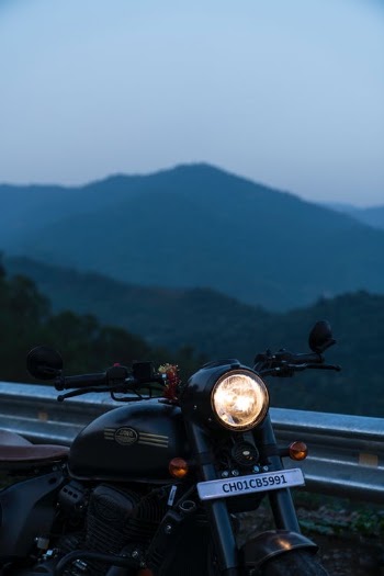 Black Motorcycle Parked Beside a Road Barrier · Free Stock Photo