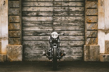 Black Motorcycle Parked Upright Near Gate