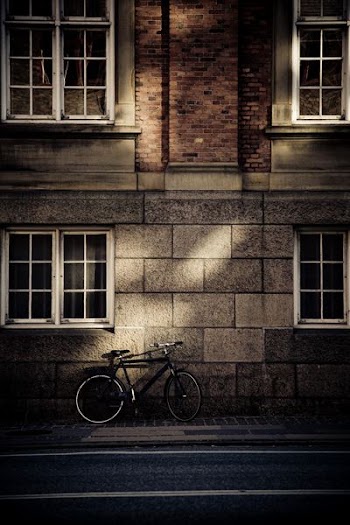 black mountain bicycle in front of brown concrete house