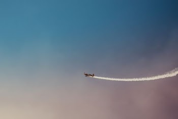 black plane under blue and grey sky