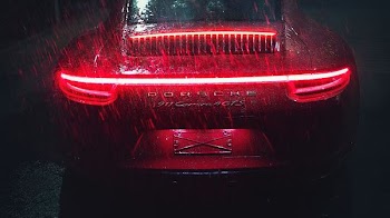 black Porsche vehicle with turned on taillights