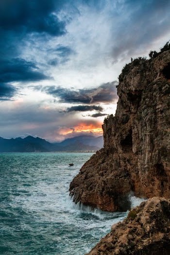 black rock formation in body of water