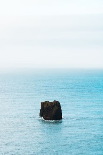 black rock on the middle of body of water