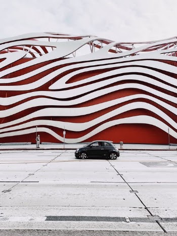 Black Sedan Parked Beside Red and White Wall · Free Stock Photo