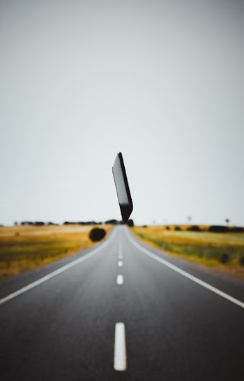 black smartphone over gray roadway