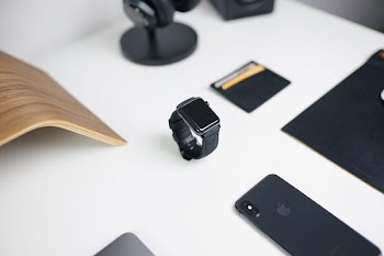 black smartwatch on table near iPhone