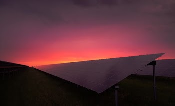 black solar panel under red and gray clouds