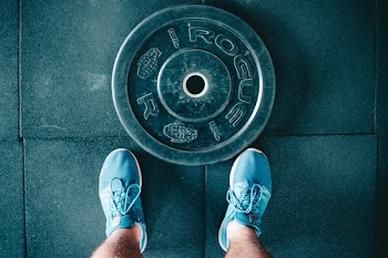 Black Steel Gym Plate and Pair of Blue Running Shoes