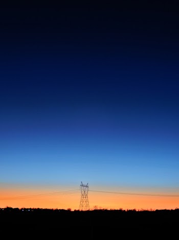 Black Transmitter Tower Under Blue and Orange Sky