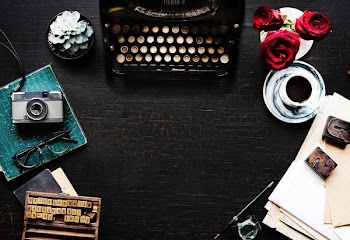 black typewriter on black wooden-top table