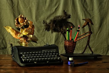 Black Typwriter Near Brown Wicker Pencil Cup