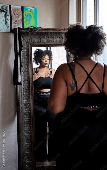 Black woman admiring herself in the mirror