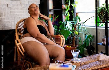 Black Woman enjoying the day in her home surrounded by plants