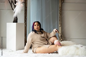 Black woman sitting on fur in front of a mirror