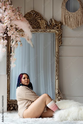 Black woman sitting on fur in front of a mirror