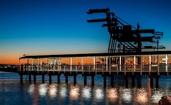 black wooden dock on body of water during sunset