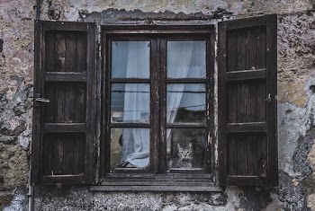black wooden window with blue curtain at daytime