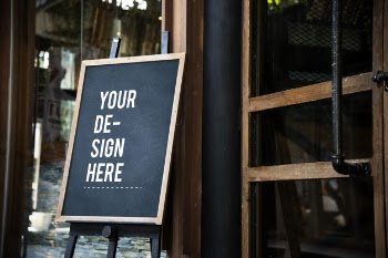 Blackboard sign mockup in front of a restaurant Free Psd