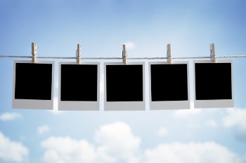 Blank instant print transfer photographs hanging on a clothesline in...
