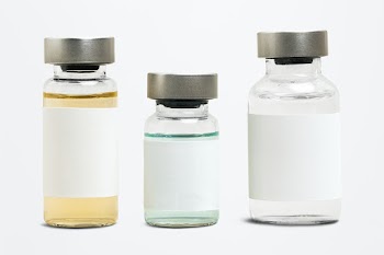 Blank vaccine label on injection glass bottles with colored liquid